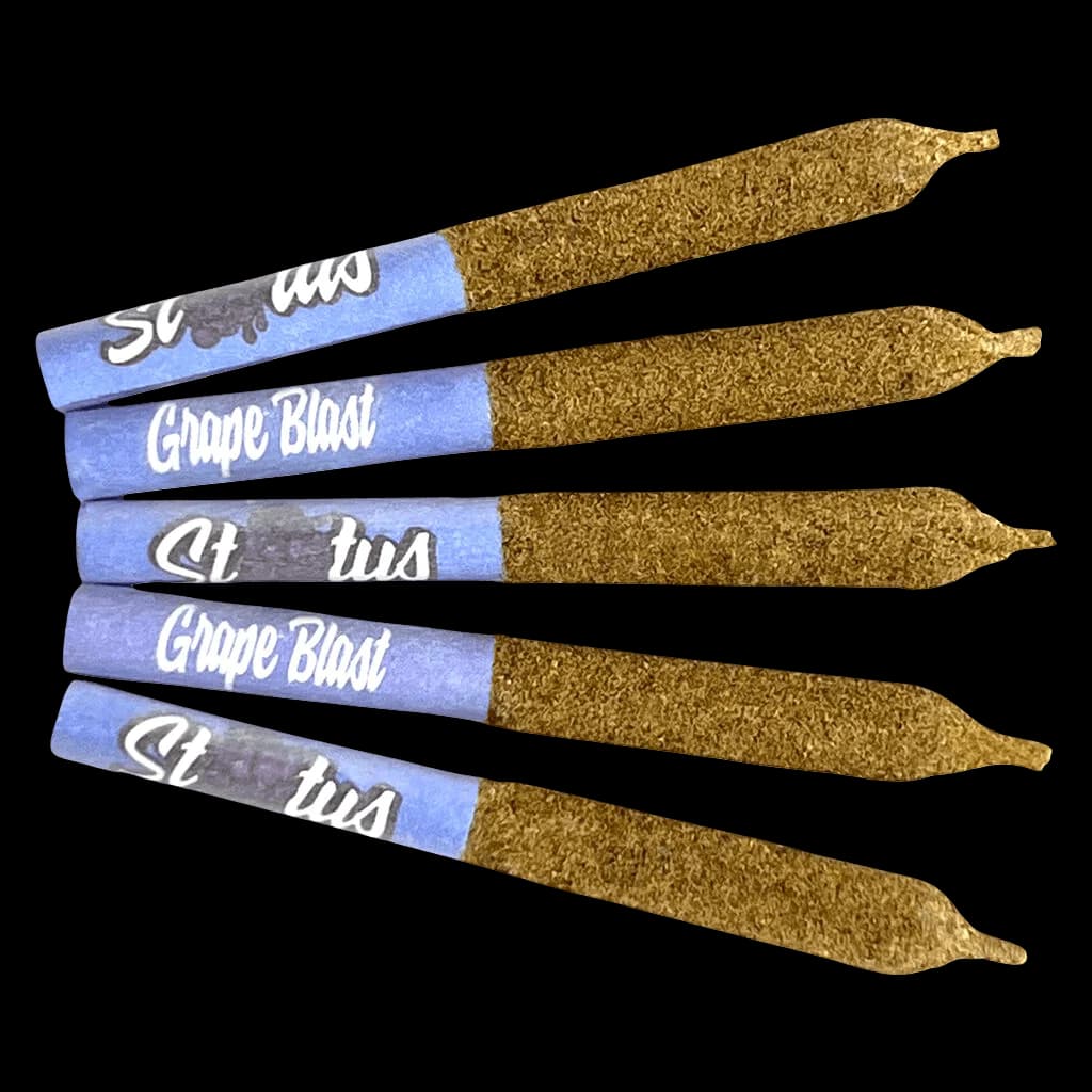 Cinq pré-roulés de cannabis Status Grape Blast avec papier bleu et papier à rouler enrobé de kief, disposés en rangées parallèles