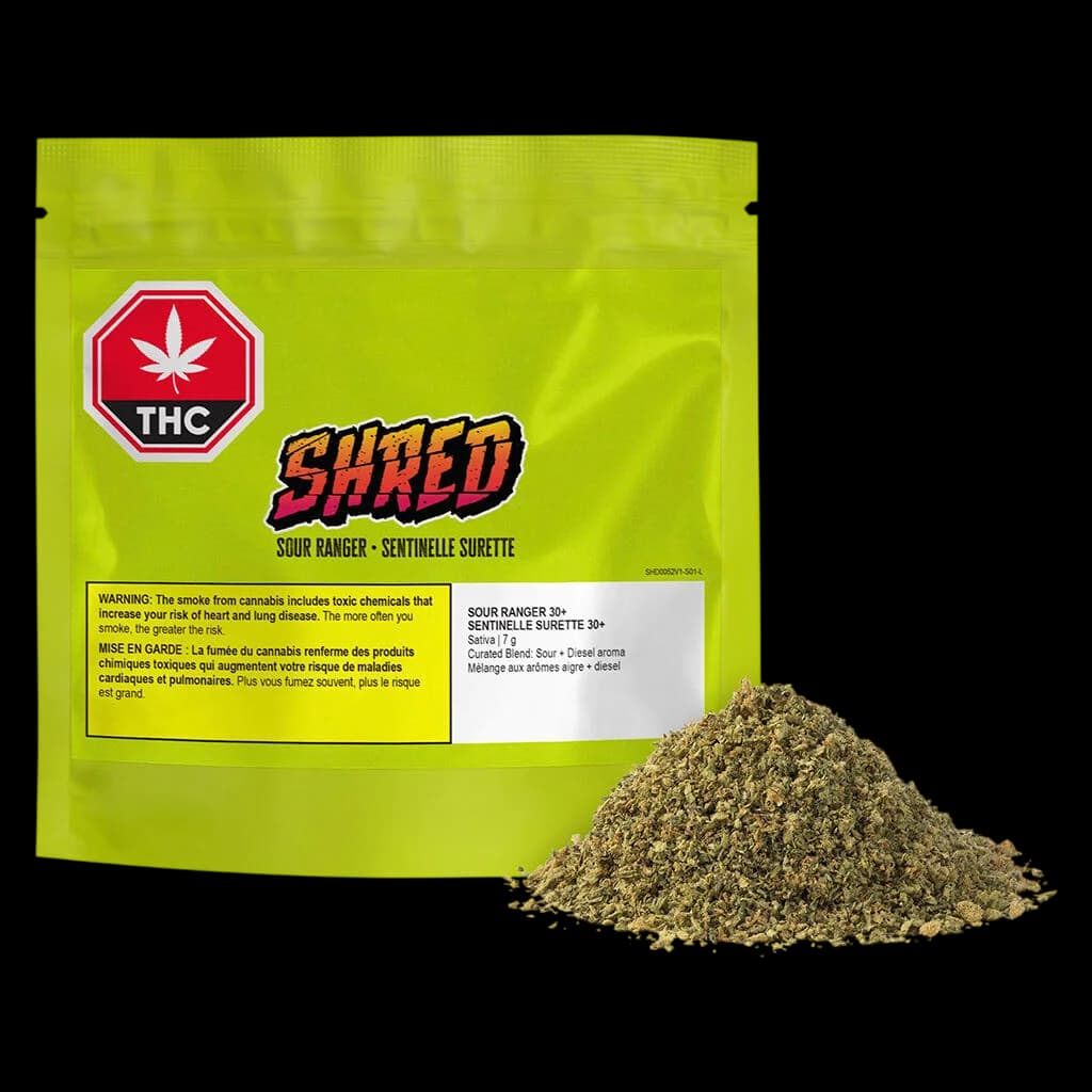 Fleur séchée de cannabis SHRED Sour Ranger 30+, emballage de 7 g avec pochette vert vif et pile de fleurs en vrac affichée