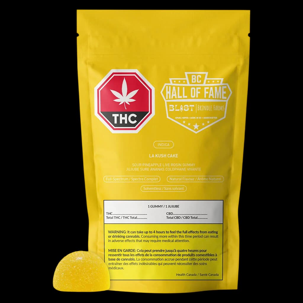 Gomme à la résine vive à l'ananas aigre La Kush Cake de Blast dans une pochette jaune avec une gomme visible, produit comestible au cannabis