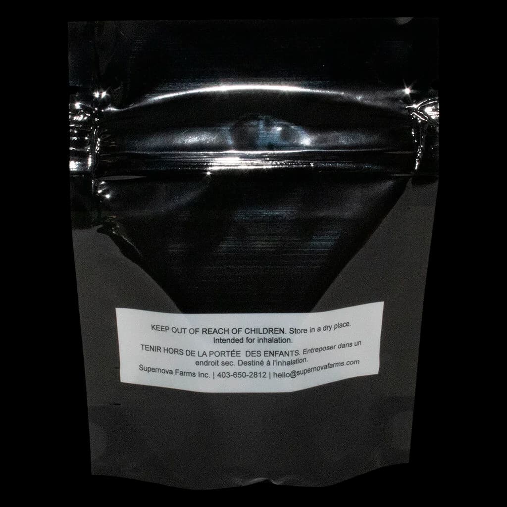 Bourgeon de fleur de cannabis séchée artisanale Supernova Farms, dense et recouvert de trichomes verts et dorés, sur fond blanc