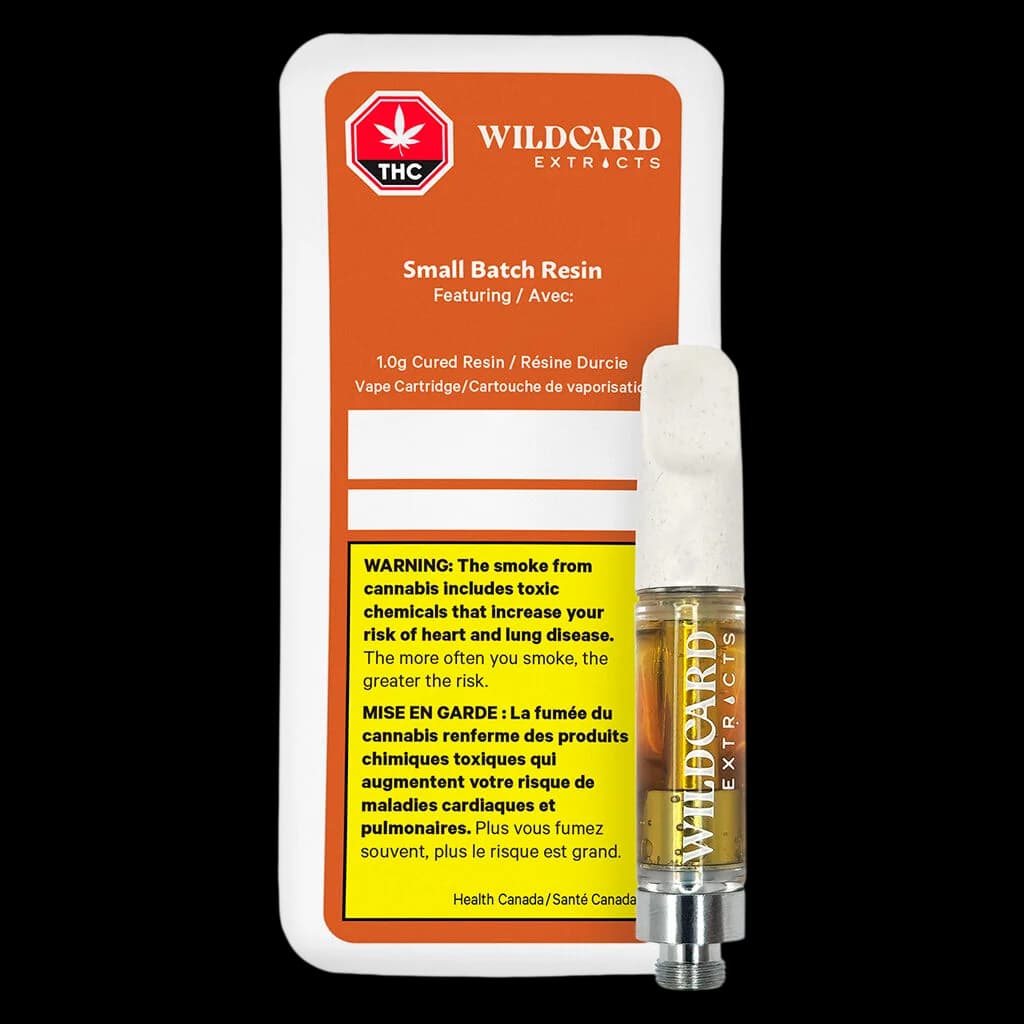 Wildcard Extracts Small Batch Resin 1.0g cured resin vape cartridge with white mouthpiece and gold-tinted glass tank, displayed beside orange packaging.